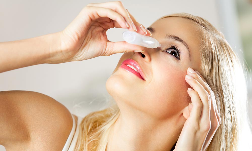 Woman putting eye drops in